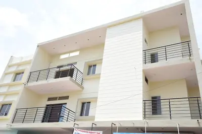a white building with black balconies on it at Daffodil serviced apartments in Mysore
