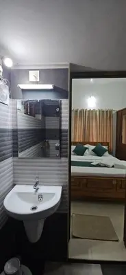 a bathroom with a sink and a bed at A cozy home bythe waterstream, tourist places near waynad in Kodenchery