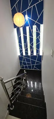 a staircase with a blue and white tiled wall at A cozy home bythe waterstream, tourist places near waynad in Kodenchery