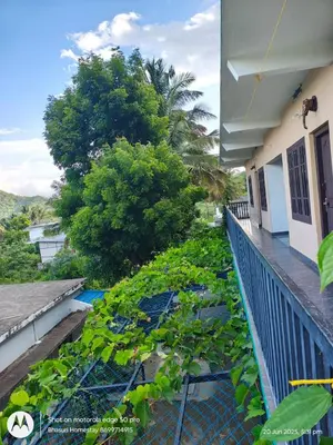 a balcony of a house with plants on it at Bhasuri AC Room 1 in Agali