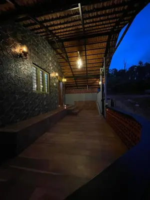 a building with a wooden walkway with lights on it at Naad Alaya Estate Stay in Siddapur