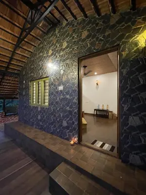 a room with a doorway into a stone wall at Naad Alaya Estate Stay in Siddapur