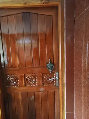 a wooden door with a bell on it at Home away from home in Palakkad in Palakkad