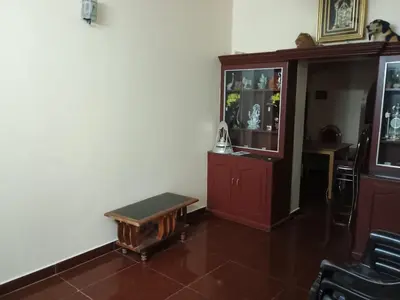 a living room with a red cabinet and a bench at Home away from home in Palakkad in Palakkad