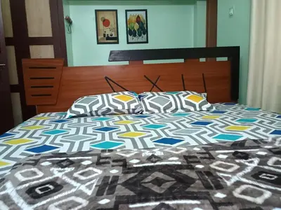 a bed with a comforter and pillows on it at Home away from home in Palakkad in Palakkad