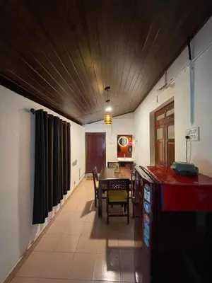 a kitchen and dining room with a table and chairs at Emnic Cottage Homestay in Meppādi