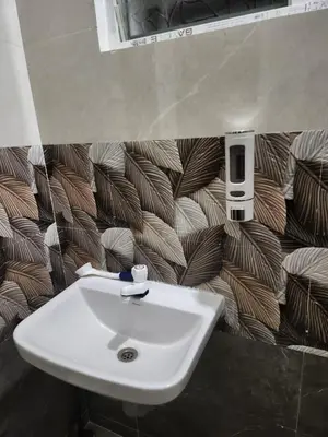 a sink in a bathroom with a brown and white wallpaper at VPM Homestay in Coimbatore
