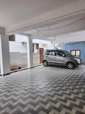 a silver car parked in a parking lot at VPM Homestay in Coimbatore