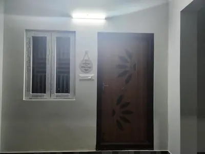 a door with a sign on it next to a window at VPM Homestay in Coimbatore