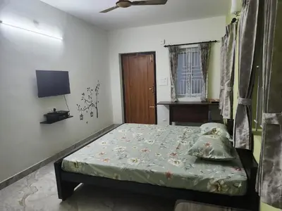 a bedroom with a bed and a television in it at VPM Homestay in Coimbatore