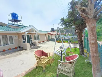 a yard with two chairs and a swing at Meadows Mountain Villa in Ooty