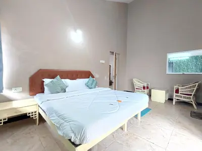 a large bed in a room with two chairs at Meadows Mountain Villa in Ooty