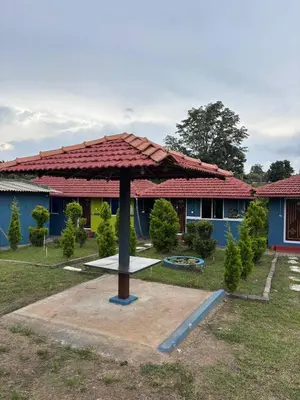 a large umbrella in front of a house at Coorg Sunrise Cottage Homestay in Kushālnagar