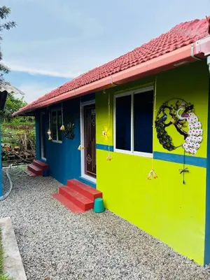 a house that is painted yellow and blue at Coorg Sunrise Cottage Homestay in Kushālnagar