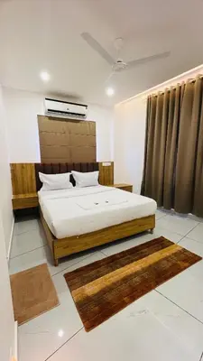 a bedroom with a bed in a room with rugs at LF Apartment in Kozhikode