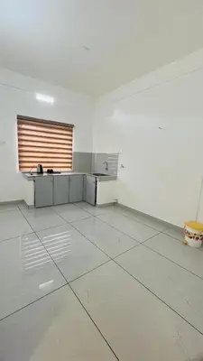 an empty white room with a kitchen and a table at LF Apartment in Kozhikode