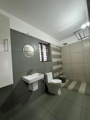 a bathroom with a toilet and a sink and a mirror at Honeyrock Farm Resort by Skybz in Kanthalloor
