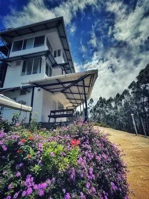 a house with a bunch of flowers in front of it at Honeyrock Farm Resort by Skybz in Kanthalloor
