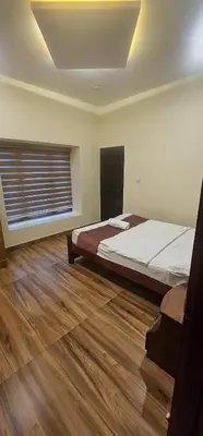 a bedroom with a large bed and a window at Romanzia Village Homestay in Mānantoddy