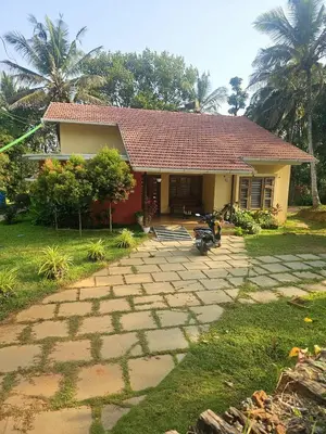 a house with a stone path in front of it at Romanzia Village Homestay in Mānantoddy