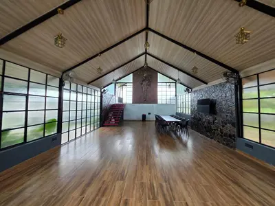 a large room with a wooden floor and windows at The Gable in Seringapatam