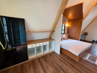 a small bedroom with a bed and a staircase at The Gable in Seringapatam