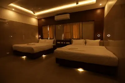 a hotel room with two beds with lights in it at Arthana Residency Hotel