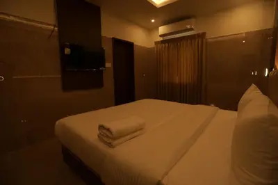a hotel room with a bed with towels on it at Arthana Residency Hotel