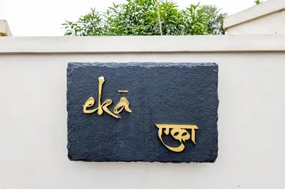 a sign on the side of a white fence at Eka in Kodungallūr