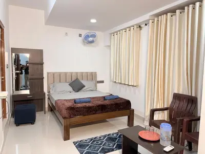 a bedroom with a bed and a table and a chair at 2 Bedrooms AC Homestay call 8O882-37972 in Mysore