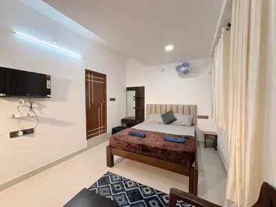 a bedroom with a bed and a tv on the wall at 2 Bedrooms AC Homestay call 8O882-37972 in Mysore