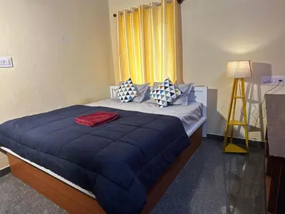 a bedroom with a bed with blue sheets and pillows at Hamsa Farmstay Mysore, Campfire, Bbq, Cricket in Mysore