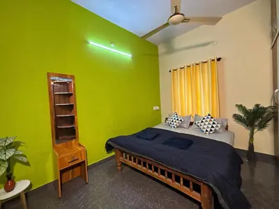a bedroom with green walls and a bed in a room at Hamsa Farmstay Mysore, Campfire, Bbq, Cricket in Mysore