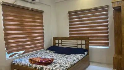 a bed in a room with wooden blinds on the windows at Divin Le Divine 150 meter to temple in Guruvāyūr