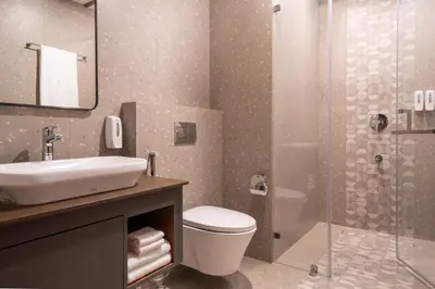 a bathroom with a toilet and a sink and a shower at CASTELO Inn in Nedumbassery