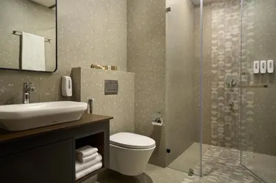 a bathroom with a toilet and a sink and a shower at CASTELO Inn in Nedumbassery