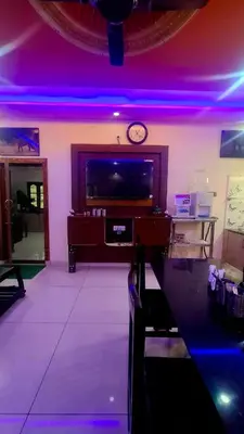 a living room with a tv and purple lights at NesaraVana - Ecostay in Hārohalli