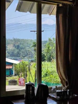 a window with a view of a green field at Tusker Valley Bamboo Room Mudumalai by Privacy Homes in Mudumalai National Park