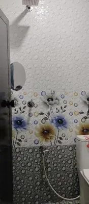 a bathroom with a mural of flowers on the wall at Misty plaza in Vattavada