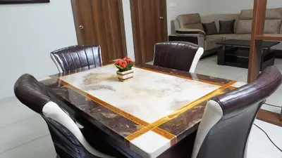 a dining room table with a marble top and leather chairs at DEJAVU TRANZS - Trishul in Coimbatore