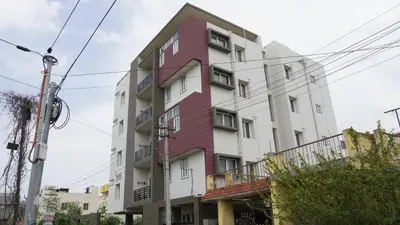 a red and white building with balconies at DEJAVU TRANZS - Trishul in Coimbatore