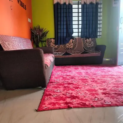 a living room with two couches and a red rug at Coorg veena villa in Madikeri