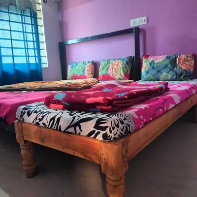 a bed with a wooden frame in a room at Coorg veena villa in Madikeri