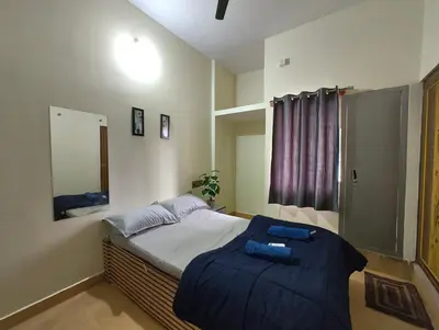 a bedroom with a bed with a blue blanket at Galaxy Homestay Mysore 4bhk - Family friendly in Mysore