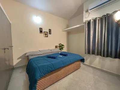 a bedroom with a large bed with a blue blanket at Galaxy Homestay Mysore 4bhk - Family friendly in Mysore