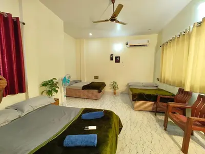 a bedroom with two beds and a table and chairs at Galaxy Homestay Mysore 4bhk - Family friendly in Mysore