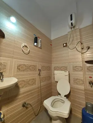 a bathroom with a toilet and a sink at Galaxy Homestay Mysore 4bhk - Family friendly in Mysore