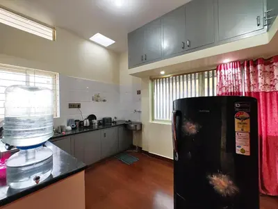 a kitchen with a black refrigerator in a room at Galaxy Homestay Mysore 4bhk - Family friendly in Mysore