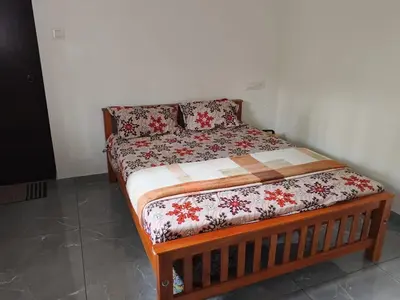 a bed in a room with a bedspread on it at Johnnys Destination in Angamali