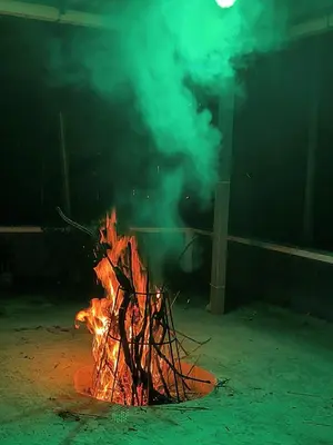a fire in a room with a person standing behind it at wild casa in Kanthalloor